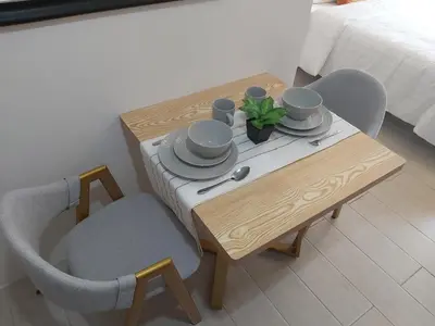 a table and chairs with a table and a bed at Pasay Staycation with Parking Space in 150 Newport Boulevard near Resort World & NAIA T3 in Manila