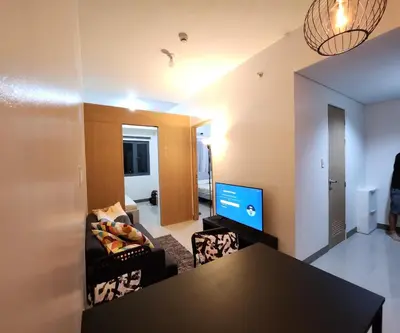 a living room with a table and a couch at Bloom Residences Condo 2Br in Manila