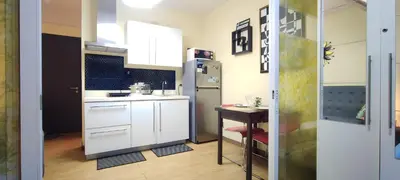 a small kitchen with a refrigerator and a table at Aveline Suites Executive City View ACQUA Private Residences near Rockwell Makati in Manila