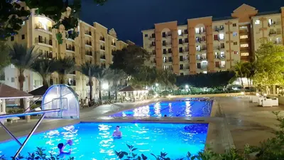 a pool at night with people swimming in it at Loft Suite in Chateau Elysee near Airport in Manila