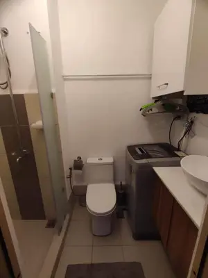a small bathroom with a toilet and a sink at Maicozy condo in Manila