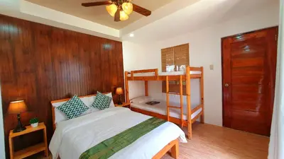 a bedroom with a bed and a wooden wall at The Farm Shack by SMS Hospitality in Amadeo