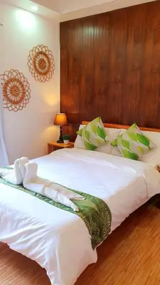 a bedroom with a large white bed with a wooden headboard at The Farm Shack by SMS Hospitality in Amadeo