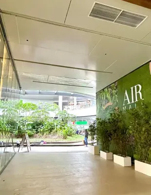 an art exhibit in a building with plants on the wall at Cozy Crib @ Air Residences - Makati in Manila
