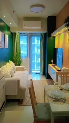a living room with a white couch and a tv at Shore 3 Residences MOA Manila in Manila
