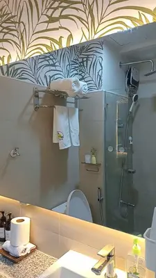 a bathroom with a mirror and a toilet and a shower at Shore 3 Residences MOA Manila in Manila
