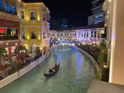 a canal in a city at night with people in a gondola at nJoy! BOHO Luxury at Venice Grand Canal in Manila