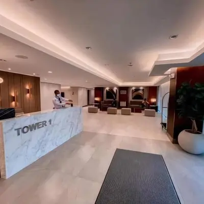 a man standing at a counter in a hotel lobby at Acellyne's Suites at Green 2 Residences with Netflix! in Dasmariñas