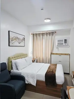 a hotel room with a bed and a chair at Acellyne's Suites at Green 2 Residences with Netflix! in Dasmariñas