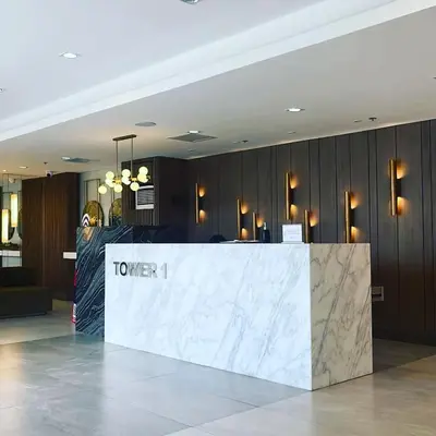 a lobby with a counter with a tower sign on it at Acellyne's Suites at Green 2 Residences with Netflix! in Dasmariñas