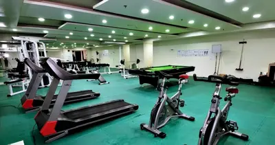 a gym with exercise bikes and a pool table at BirchTower Studio Condo with Balcony & Pool - Carosa Staycation in Manila