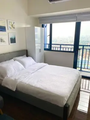 a large bed in a room with a large window at Scandinavian Studio in Makati in Manila