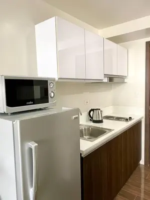 a kitchen with a white refrigerator and a microwave at Scandinavian Studio in Makati in Manila
