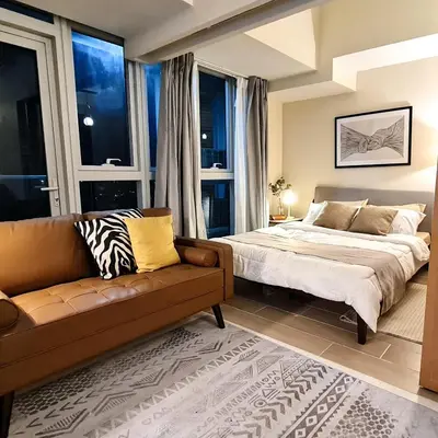 a bedroom with a bed and a couch at Luxe Bonifacio Global City Taguig Uptown Condo Hotel 1 BR Suite in Manila