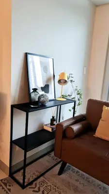 a living room with a couch and a table with a television at Luxe Bonifacio Global City Taguig Uptown Condo Hotel 1 BR Suite in Manila