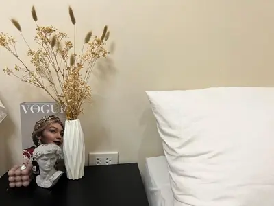 a table with a vase and a statue on a bed at Staycation Condotel Room To Stay in Manila