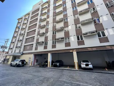 a large building with cars parked in front of it at Staycation Condotel Room To Stay in Manila