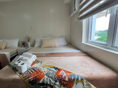 a small room with two beds and a window at Staycation Condotel Room To Stay in Manila